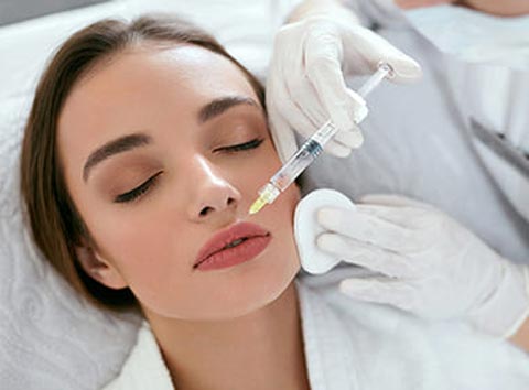 A woman receiving lip filler injectable in her upper lip